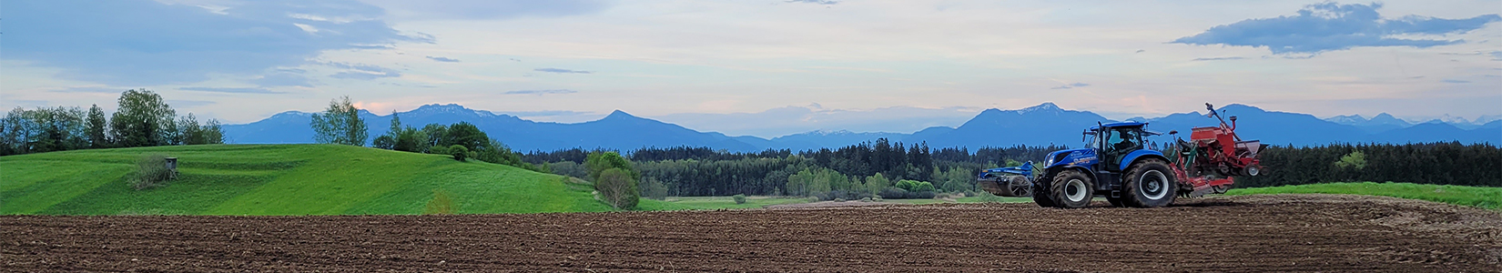 Felder und Wälder vor der Alpenkulisse auf einem Chiemsee Bauernhof