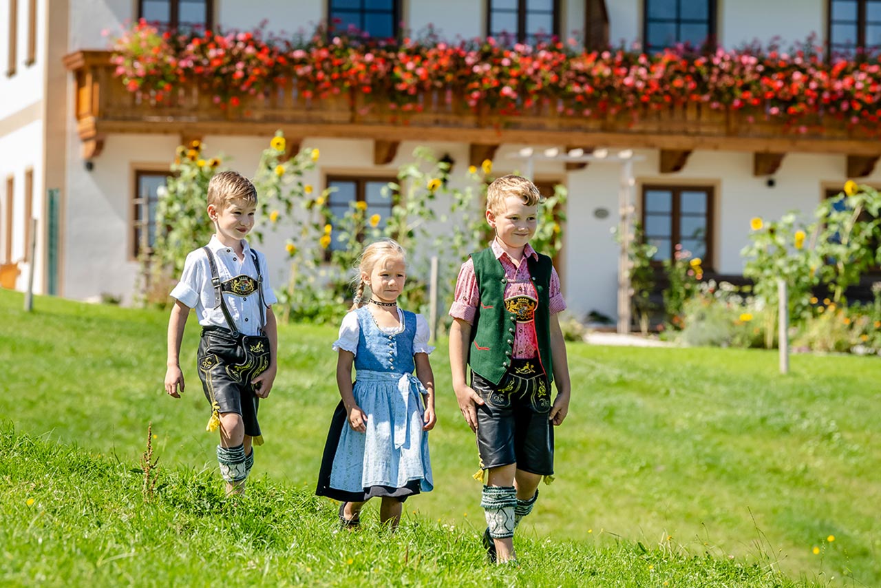 Kinder in Lederhosen und Dirndl vor einem Chiemsee Bauernhof